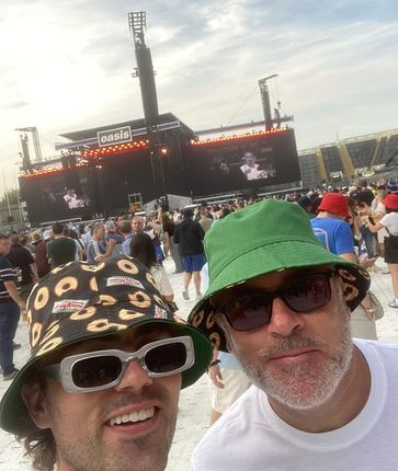 Adam and Damian in bucket hats at an outdoor gig