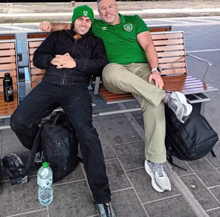 Adam and Damian waiting on a train platform on a trip abroad